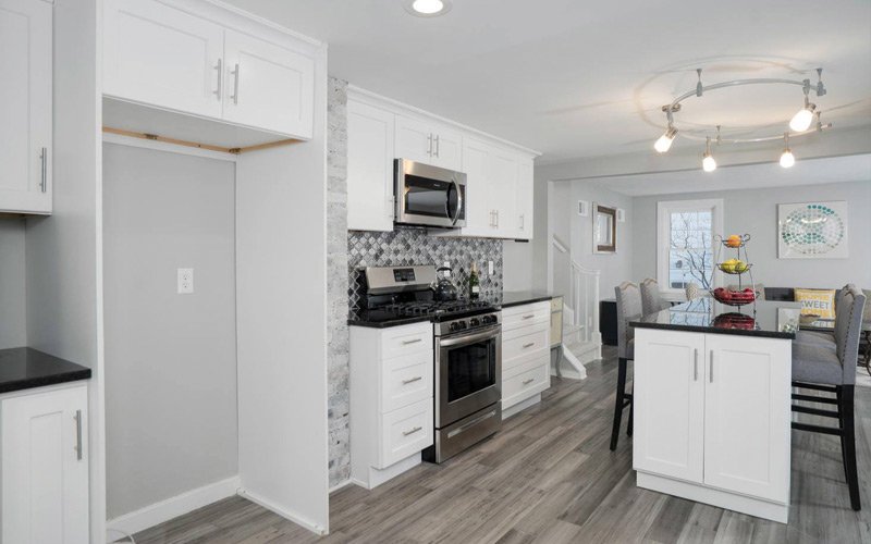 White kitchen cabinets with grey backsplash