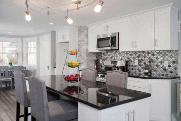 White kitchen cabinets with grey backsplash