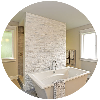 Freestanding tub with stone wall and shower